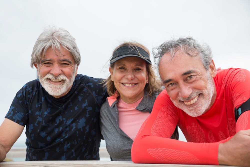 Senior friends smiling and enjoying outdoor fitness together